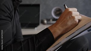 close view of man holds a notebook, writing notes, lyrics, or poems