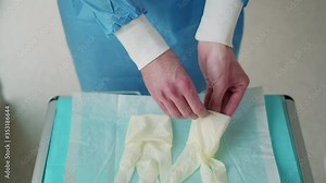 Dentist putting on surgical gloves in dentists office