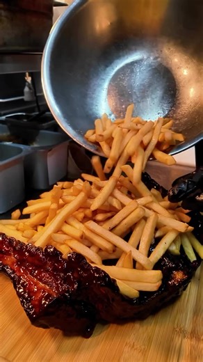 Who let bro cook?! Loaded Fries stacked on a butterflied rack of pork ribs that got so much meat on them you might as well call it pork belly with bones.What do you think of this crazy food experiment Should this be a special?