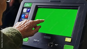 Elderly woman's finger pushing buttons on a touchscreen on a voting machine during a USA election where the screen is a chroma key green screen.