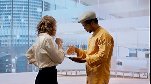 Property broker presenting real estate investment opportunity to client, reviewing blueprints layouts on tablet for leasing contract. Agent discussing architectural design for relocation. Camera A.