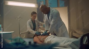 Doctor performing cpr in emergency unit room. Nurse assisting with oxygen mask.