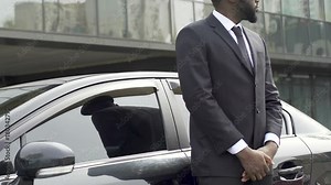 Private driver and bodyguard standing near car waiting for rich vip client