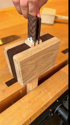 Using a small hand plane to shave thin wooden strips from the edge of a timber board on a workbench