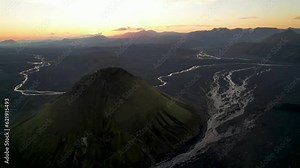 Aerial view of Maelifell mountain at sunset, a tall volcano that stands out in a desert of black sands, Iceland.