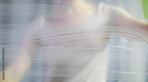 the woman washes a window. Splashes soapy water on the glass. Cleans the glass from dirt.