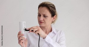 Woman confused by wrong plug and socket near white wall in office. Lady in blouse can not connect appliance to electrical network in studio Stock Video