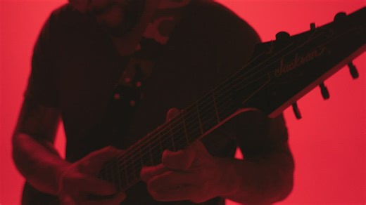 Musician playing a guitar solo on a red background - Free Stock Video
