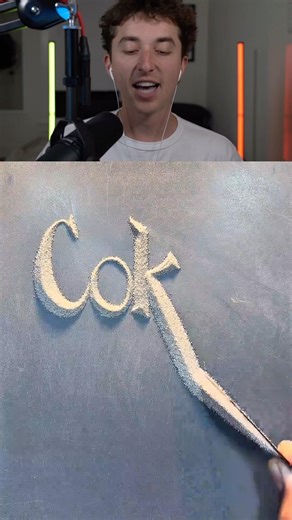 Writing The Word Coke With Sand