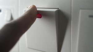 A finger turning on lighting switch .