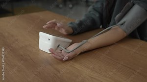 woman use blood pressure machine and have health check at home