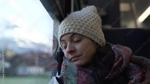 Woman falling asleep while traveling by train. Female passenger leaning on window closes eyes while traveling in motion