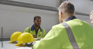 Lunch break at industrial factory. Group of engineers and foremen having meal in plant cafe. Talking, communicating, eating