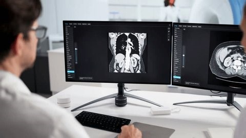 clip-3982364195-surgeons-using-desktop-monitor-mri-screening-hospital