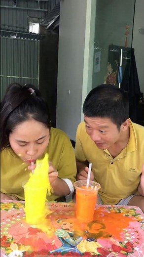 The challenge of blowing bubbles in a cup of water between the two sisters.