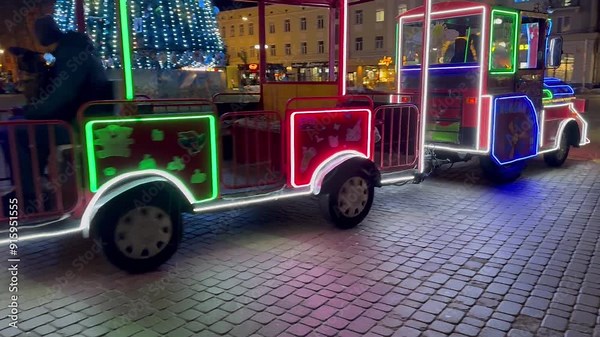 Night train journey through lively city square, vibrant lights Stock Video