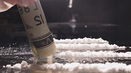 Cocaine junkie snorting line of coke or crushed pills with rolled US...