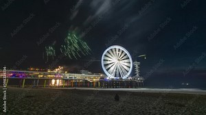 4k time lapse video of the Scheveningen pier with fireworks and rotating illuminated Ferris Wheel at the Dutch north sea coast