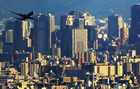 摩天楼を背にテイクオフ！　兵庫県内のあるスポット、超望遠で伊丹空港を撮影すると…ドラマチックな一枚に