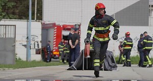 A team of firefighters swiftly readies water hoses, demonstrating their urgent response to prepare for a dangerous fire suppression mission, highlighting their commitment to firefighting and safety.