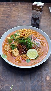 Creamy comforting Khao Suey!! Recipe: Sauté red curry paste - 2-3 sp Add Dabur Hommade Coconut Milk 200ml Vegetable Stock 200ml Palm Sugar 15-20g Soy Sauce 2-3 sp Tofu Cubes 200g Assembly- Add cooked noodles in a bowl, add the broth, sliced onions, Scallion, garlic crunch chilli crisp, Crispy fried noodles, lime wedge and enjoy Recreate this delicious recipe using @daburhommadeofficial Coconut Milk 🥥💙 #khaosuey #comfortingrecipes #easyrecipes #hommade #daburhommade | ramanokram
