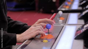 Close up view: man hands playing retro arcade machine game and pushing orange buttons. Gaming, 80s, hobby, vintage, technology, retro video game and leisure time concept