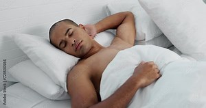 Man, resting and sleeping in bed at home, peace and dreaming or relax on sunday morning. Male person, comfortable and blanket for stress relief, lazy and house nap on soft bedding and calm on weekend