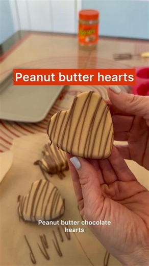 Hannah Gray | One Sweet Mama on Instagram: "250 grams white almond bark (or coating like Ghirardelli!) 250 grams creamy peanut butter Melt until fluid. Pour in an Silicone heart mold, halfway filling it. Let set up until solid (you can put it in the fridge but you don’t have to!) Melt chocolate, pour on top of the peanut butter. Drizzle not necessary but pretty! #food #easyrecipes #reeses"