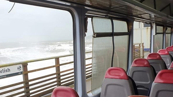 First pictures show train windows smashed by waves leaving one injured