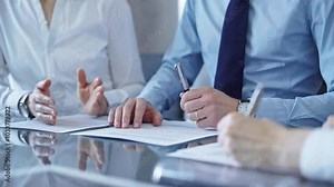 Business people signing important documents during a corporate meeting. Win-win concept for diverse team group