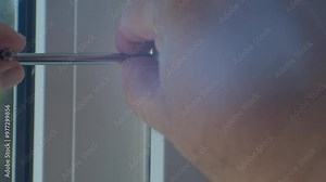 Repair and adjustment of a plastic window. The hands of craftsmen adjust the mechanism of a plastic window with a special tool. Close-up.