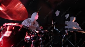 Hooded Drummer Performing on Stage, Mysterious figure in white hoodie playing drums, surrounded by red lights.