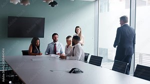 Group Collaborating On Task At Graduate Recruitment Assessment Day Whilst Being Observed By Recruitment Team