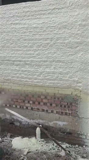 spraying liquid foam insulation on the brick wall to improve energy efficiency in the building