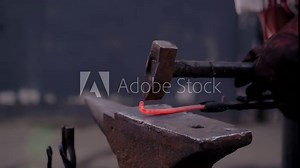 Super slow motion: professional blacksmith showing how to work with metal on anvil at summer handicraft festival - close up view. Handmade, learning, education, craftsmanship and blacksmithing concept