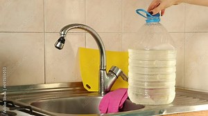 A homemade faucet made from a plastic bottle stands in the kitchen at home when there is no water in the tap, ideas for the home