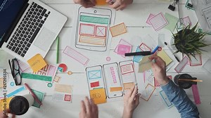 UX designers putting post it notes on app layout