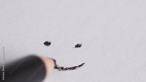 Hand drew a smiley on white paper. A pencil draws a smiley face