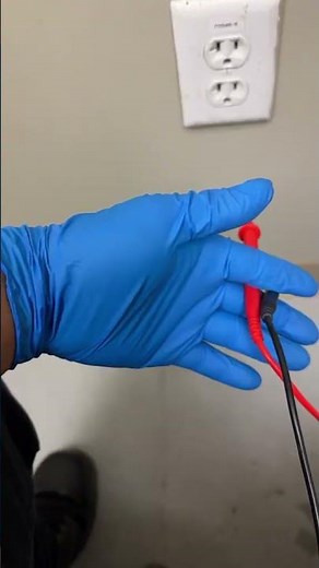 Checking a wall electrical outlet with a multimeter