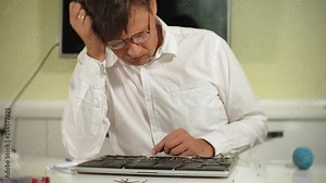 A man is repairing a laptop. The concept of computer repair. Close up of man repair laptop motherboard with a screwdriver. Maintenance of the hardware of the motherboard. Disc holder, computer repair