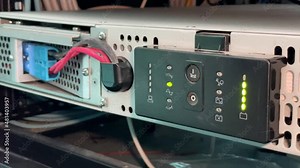 Technician installing and test UPS battery to electrical equipment control cabinet, technology and service working concept.