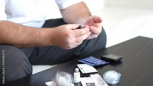 Men check their sugar levels using a lancet pen and glucometer