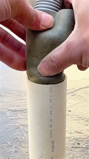 installing a water hose into a pipe using a cut motorcycle inner tube so that it fits when inserted.