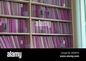 Valmiera, Latvia - February 14, 2026: Bright indoor library features organized pink file folders on shelves with visible labeled dividers for easy identification Stock Video Footage - Alamy