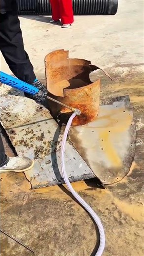 High‑pressure jet strips rust from metal cylinder