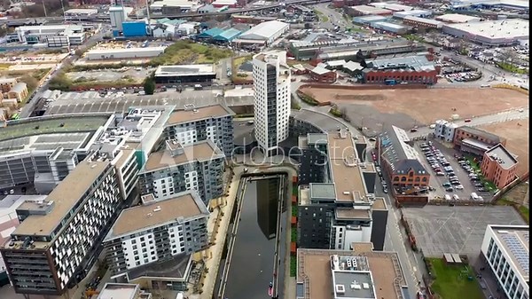 Aerial drone footage of the area in the Leeds city centre known as the Leeds Dock along side the canal flying upto the tall apartment building known as Bridgewater Place