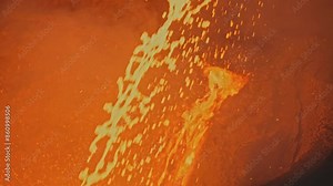 Splashes of molten metal at factory. Stock footage. Bright splashes of molten metal move in streams. Metallurgical plant with splashes and streams of molten metal