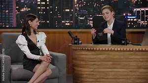 Late-night talk show female host having a funny conversation with celebrity guest in a studio. TV broadcast style show. Shot with RED cinema camera