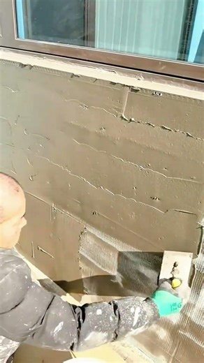 smoothing cement on the reinforcement layer of exterior walls using a putty knife for a neat finish
