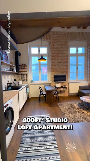 Would you live in this 400-sqft loft apartment? For the amount of space, I think it's very well designed & quite livable! Inside, there is a spacious floor plan including a kitchen with a washer, a dining table for 2, a living room with a sectional couch & mounted TV, a wardrobe & storage throughout, a bathroom with a tile shower, & a lofted bedroom with some built-in storage! #loft #apartments #tinyhouse #belgrade #serbia | Dream Big Live Tiny Co.